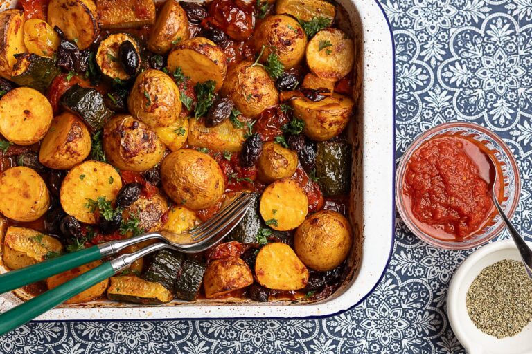 Lähivaade Vahemere stiilis ahjuköögiviljadest – röstitud kartulid, suvikõrvits, Kalamata oliivid ja tomatikaste ahjuvormis.